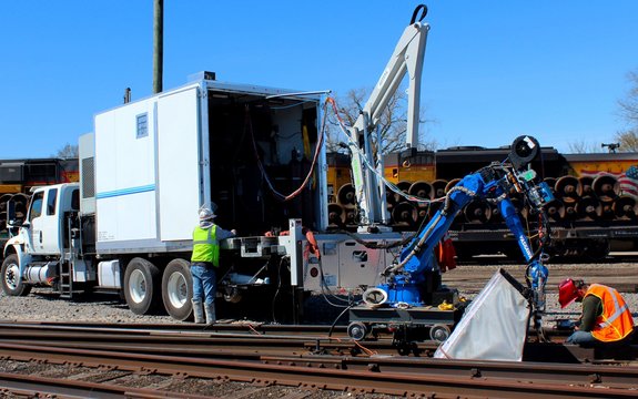 Mobile laser welding unit for track repairs consisting of a Yaskawa robot arm and Laserline coating optics 